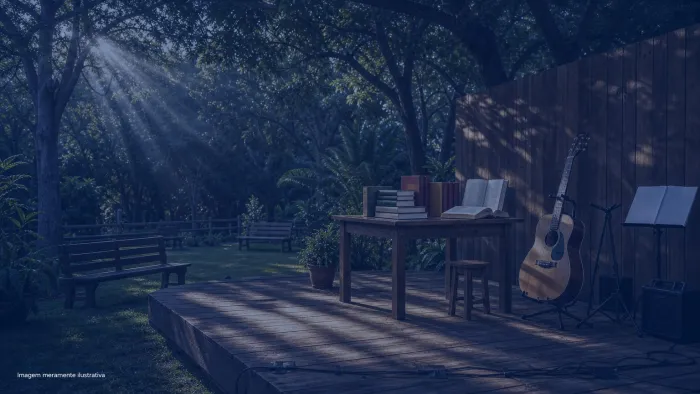Palco ao ar livre em parque arborizado com violao e livros sobre a mesa, imagem meramente ilustrativa