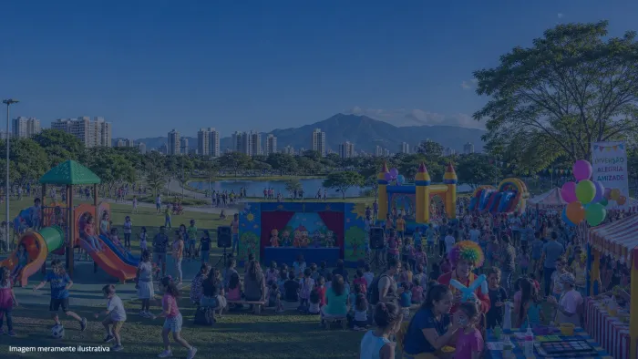 Parque urbano com brinquedos infláveis e famílias em dia de festa, imagem meramente ilustrativa