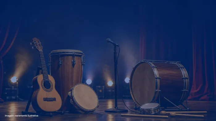 Instrumentos de samba como cavaquinho, pandeiro e surdo sobre palco iluminado, imagem meramente ilustrativa
