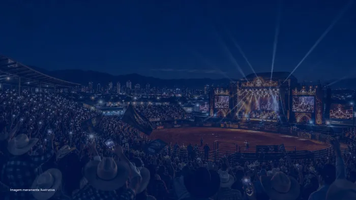 Arena de rodeio à noite com palco iluminado e arquibancada cheia, imagem meramente ilustrativa