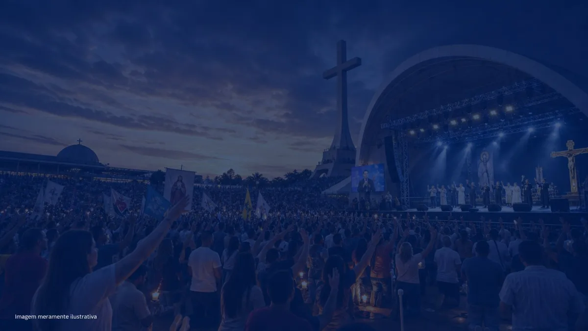 Fiéis reunidos em acampamento religioso ao entardecer com grande cruz ao fundo, imagem meramente ilustrativa