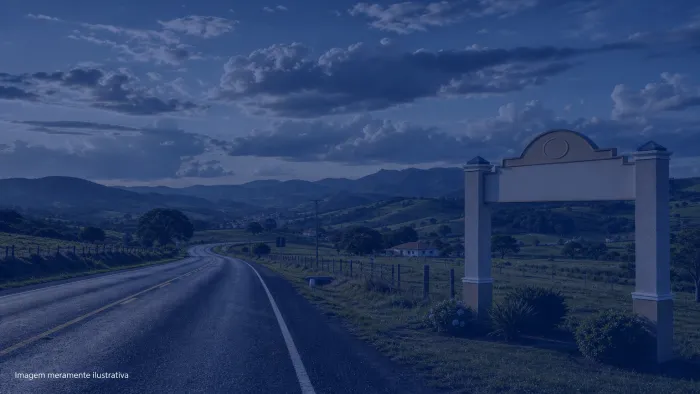 Rodovia cortando área rural com morros e céu amplo ao fim da tarde, imagem meramente ilustrativa