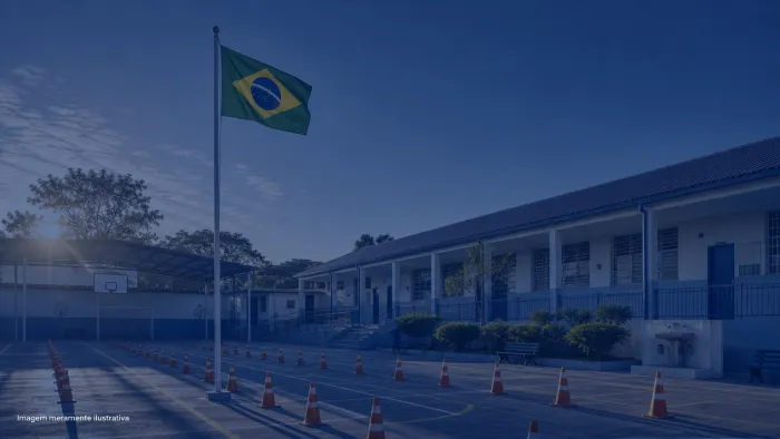 Patio de escola com bandeira do Brasil hasteada e fileiras de cones, imagem meramente ilustrativa